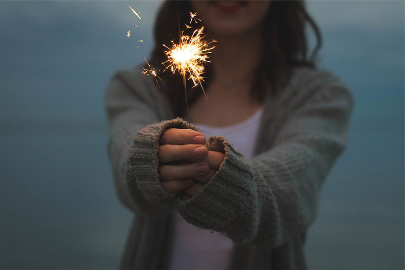 Woman holding sparklers.